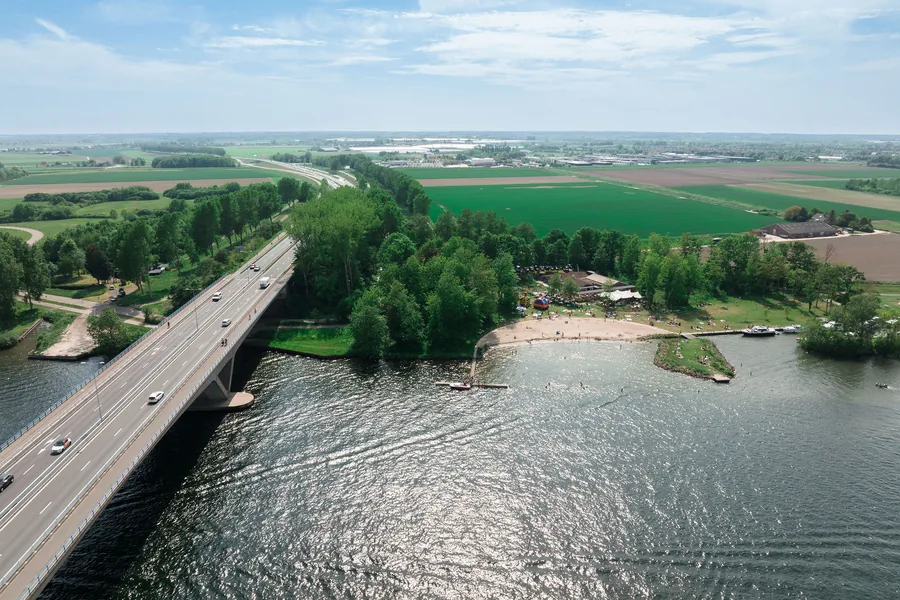 Luchtfoto van de Brielse brug, het meer en het terrein van Breezze eronder