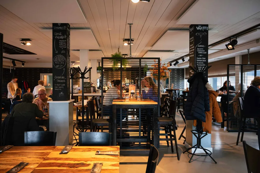 Het interieur van de brasserie met krijtborden boven de bar
