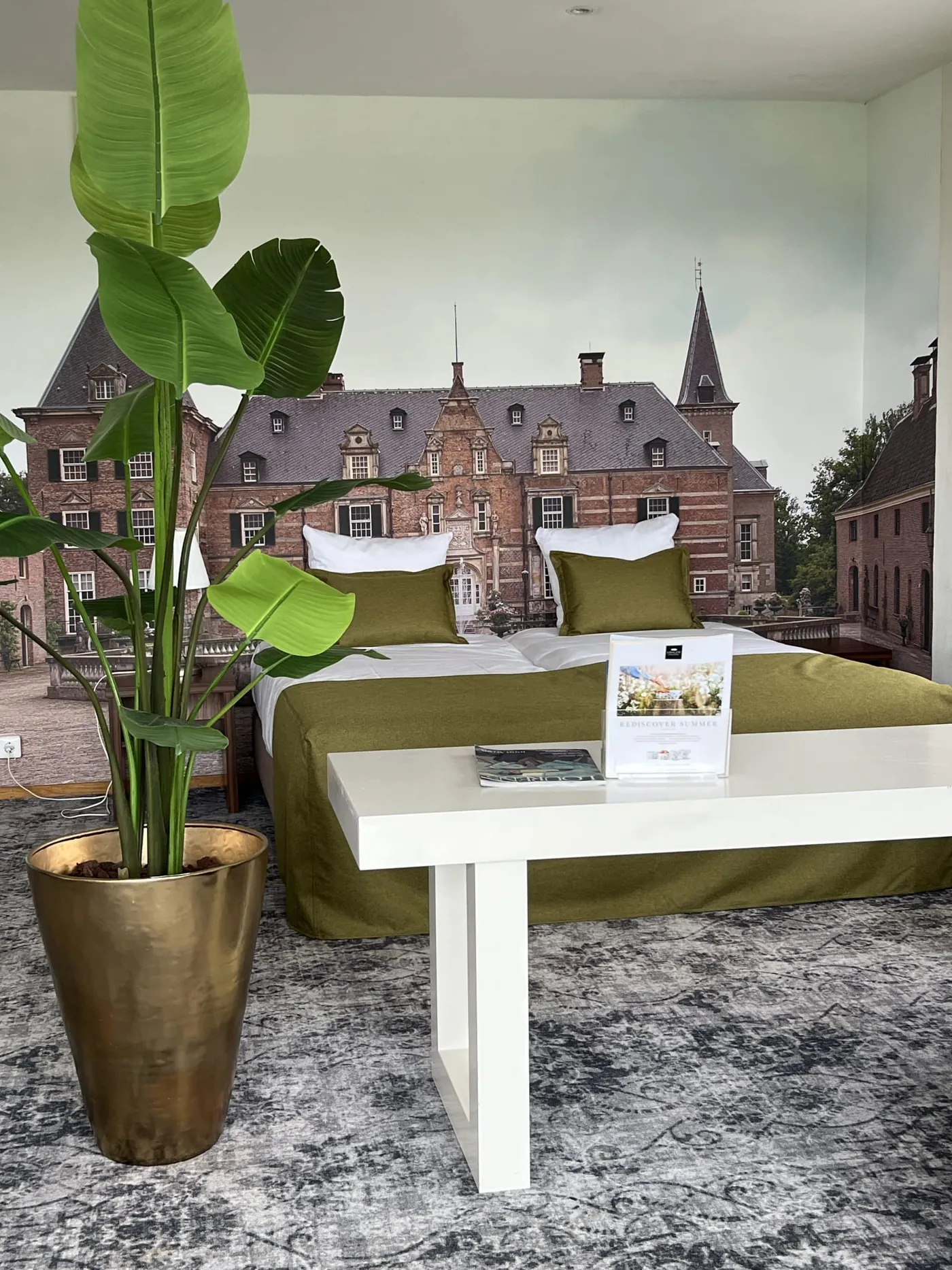 Een hotelkamer met een groot fotobehang van het kasteel achter het bed