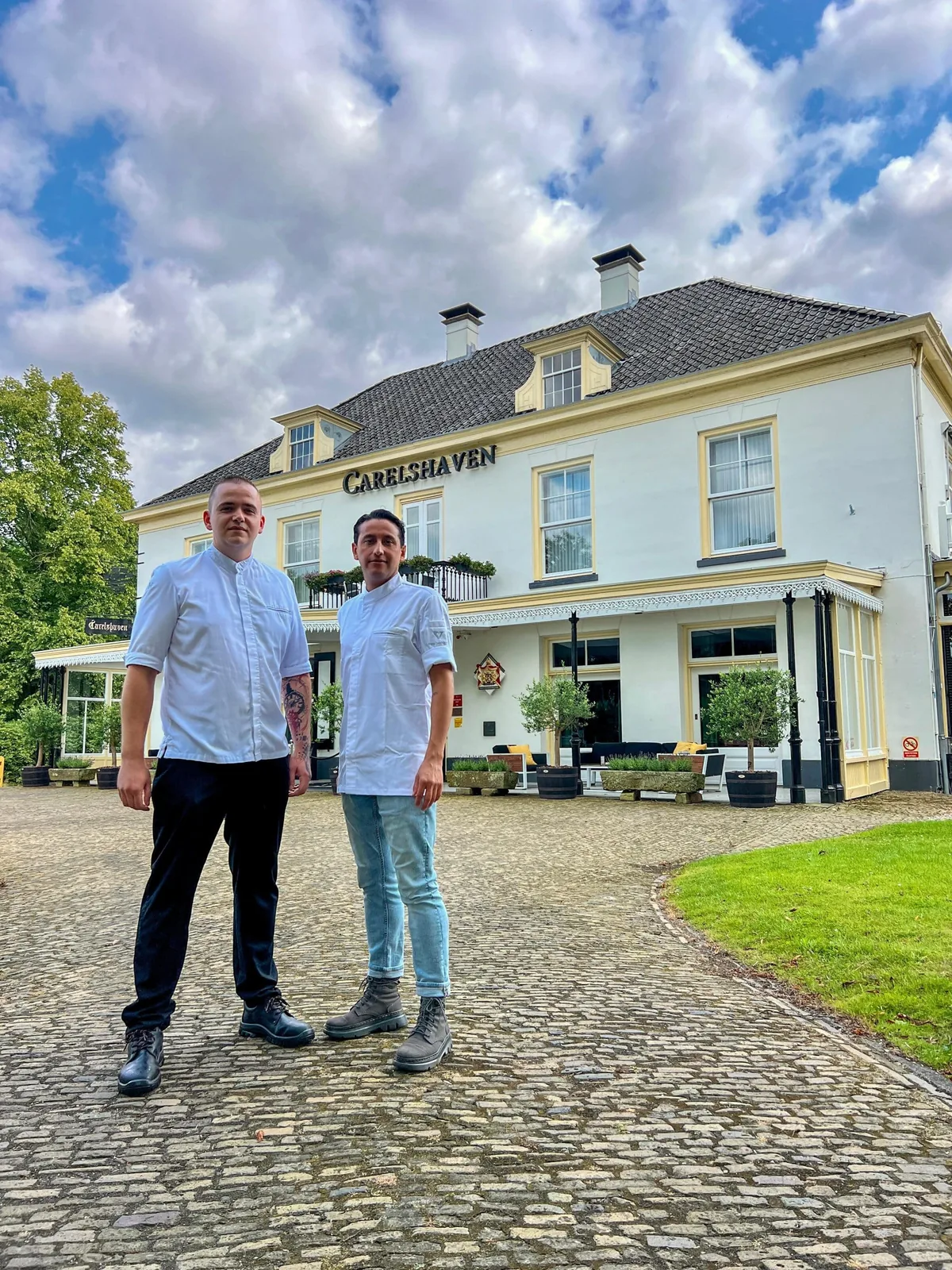Twee chefs staan voor de witte gevel van Landgoed Hotel en Restaurant Carelshaven